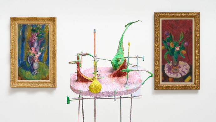 Photograph of two paintings with a sculpture inbetween
