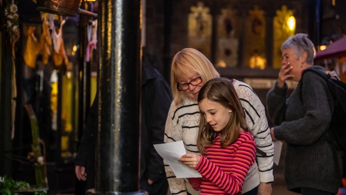 An adult and child looking at a trail in the victorian streets at Abbey House Museum