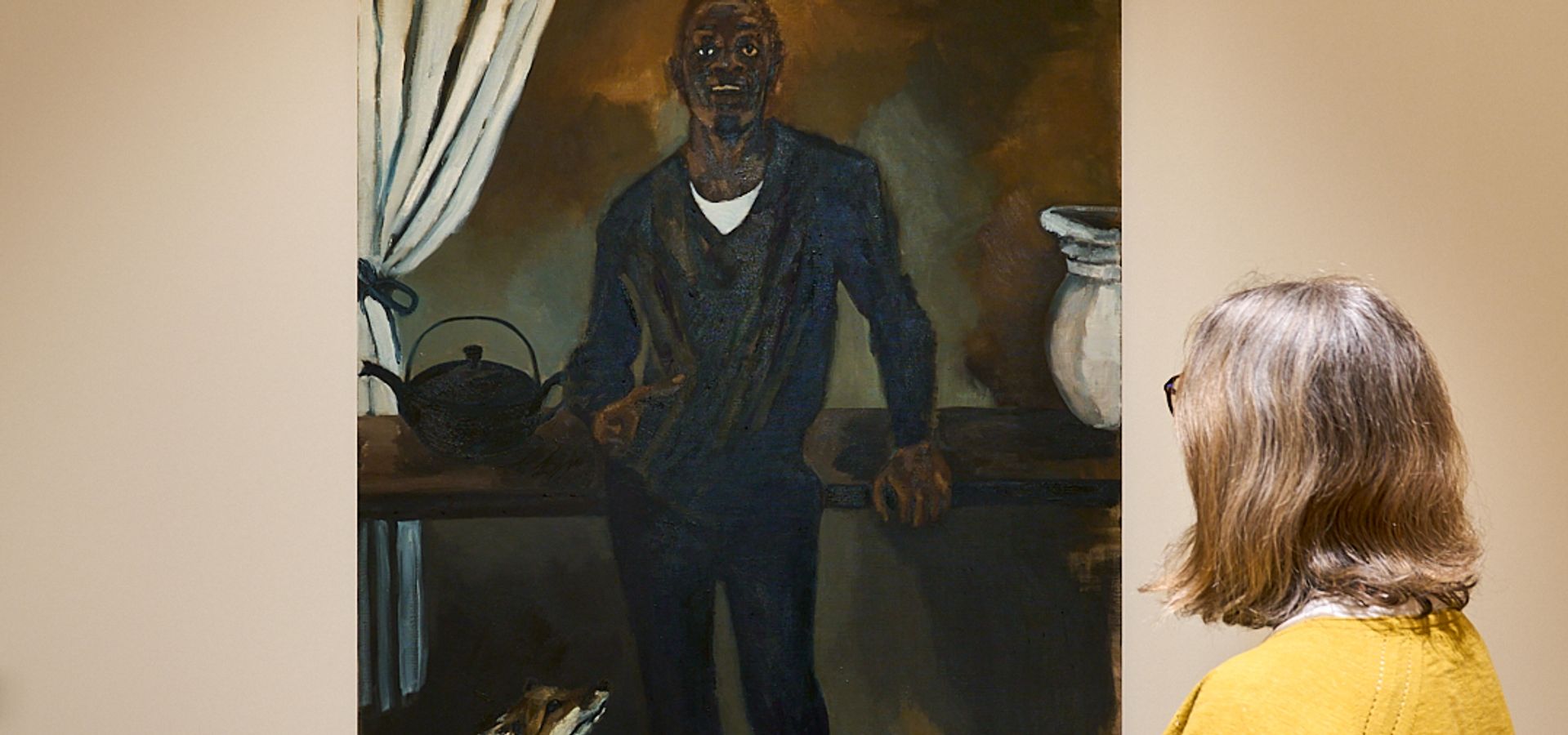 A woman stood looking at a painting of a man