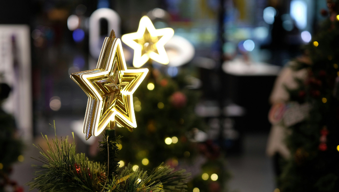 An illuminated star on top of a tree