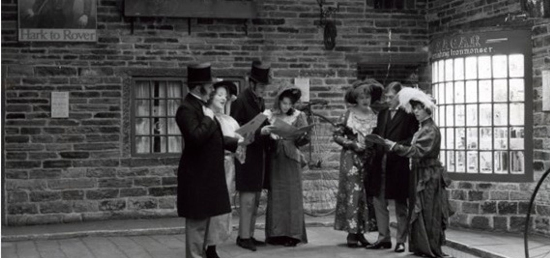 A group of people stood in Abbey House Museum streets reading