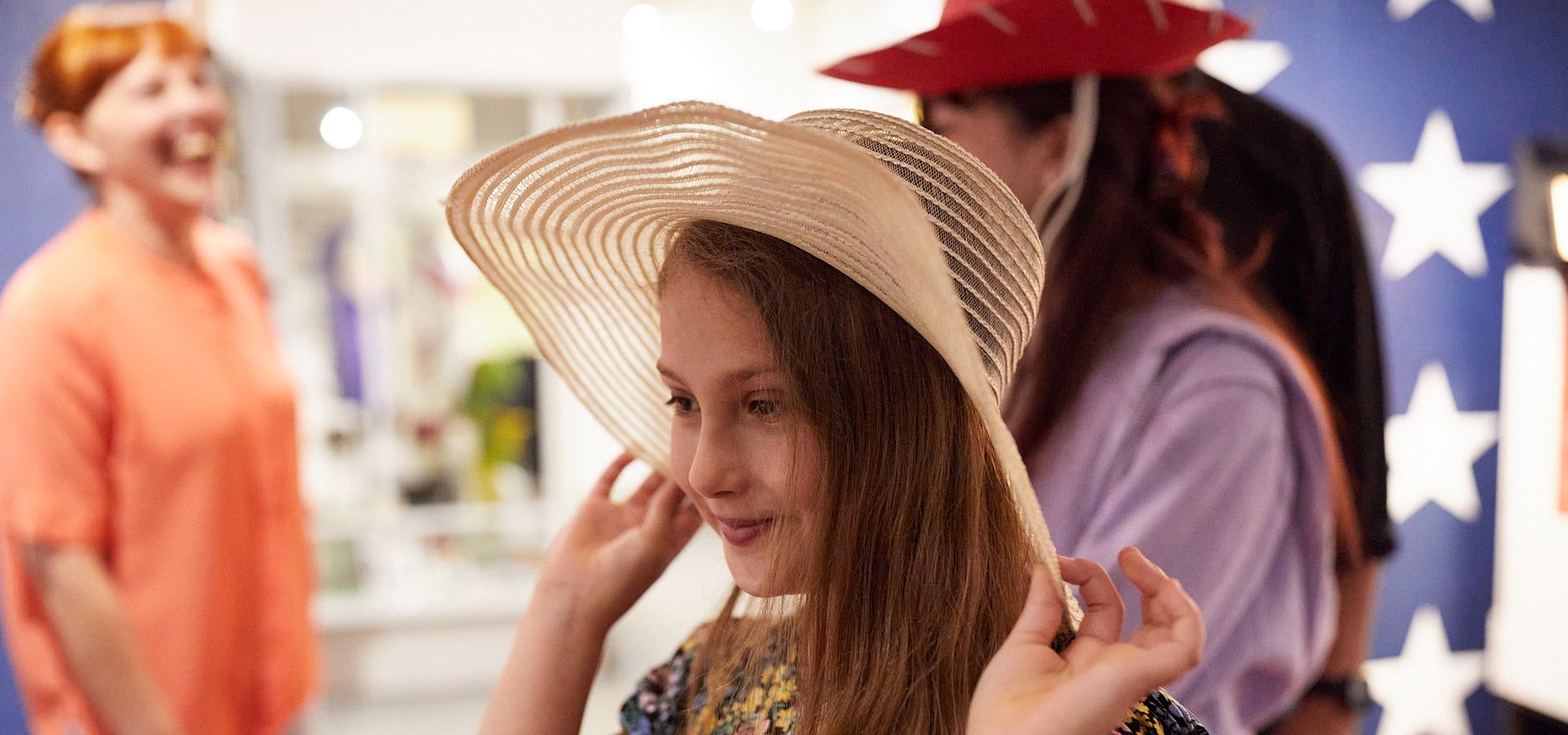 Two girls trying on old fashioned hats in the Museum