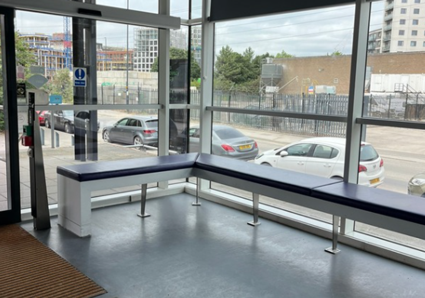 The waiting area in Leeds Discovery Centre with benches around the corner windows