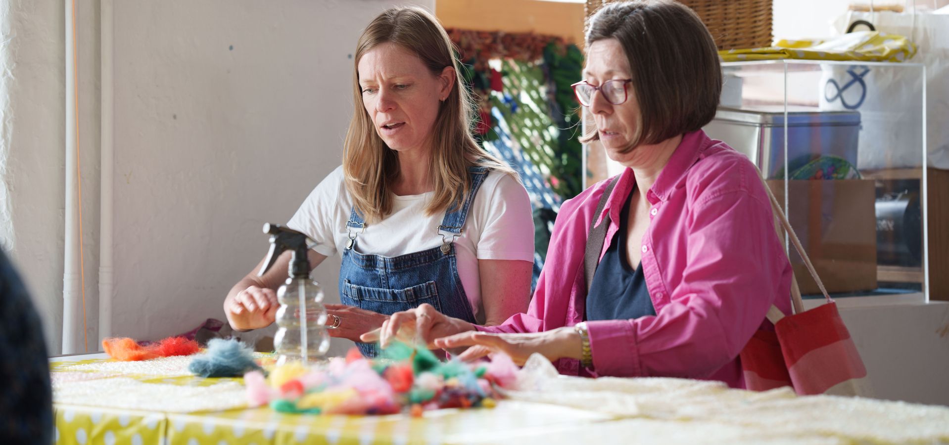 Two adults sat at a table felt making