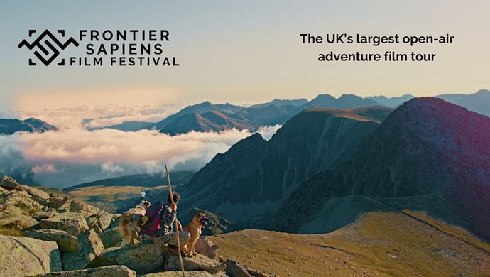 Beautiful mountain landscape with man and two dogs. Text reads "The UK's largest open-air adventure film tour"