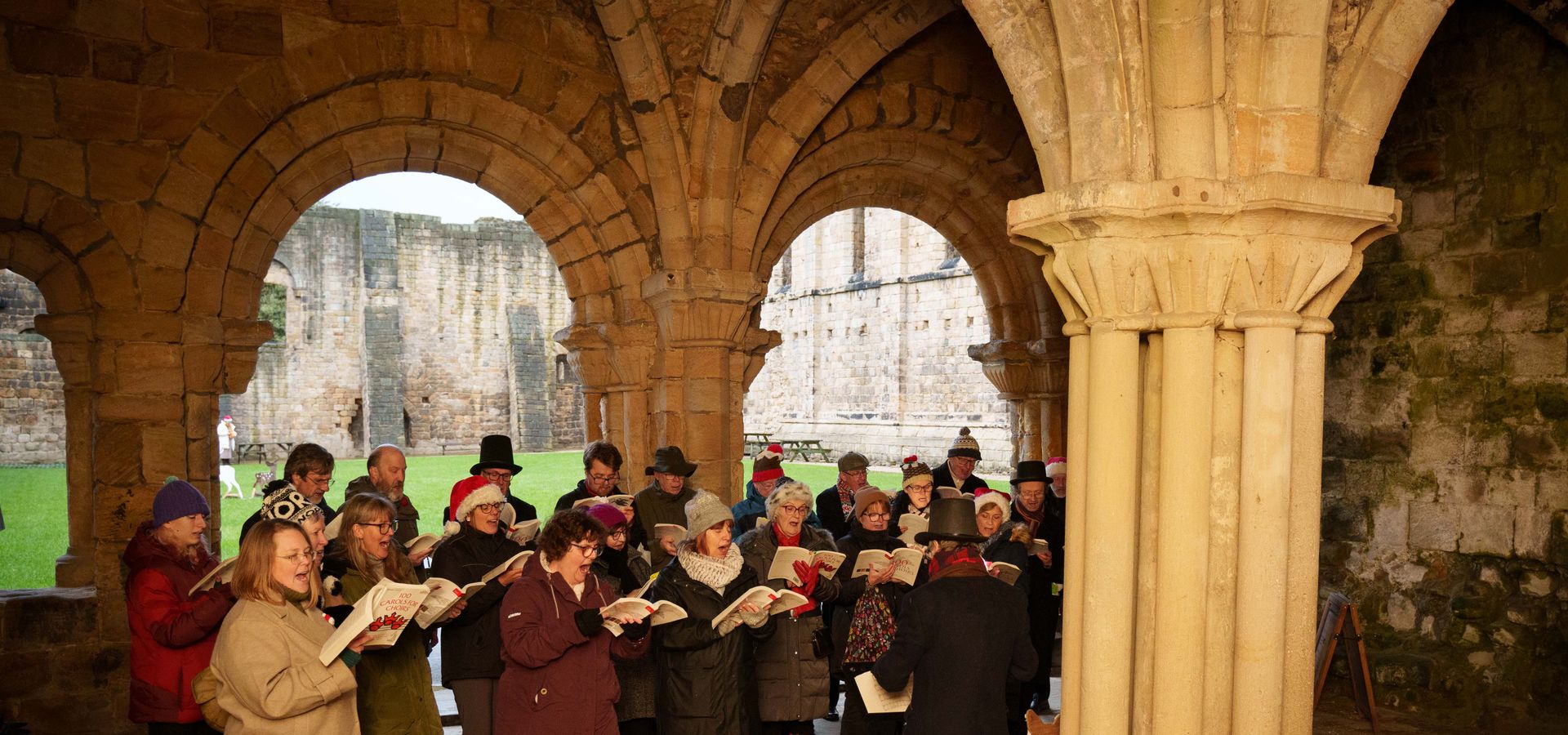 A choir under arches in Kirkstall Abbey