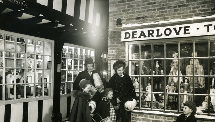 a victorian family window shopping in a street