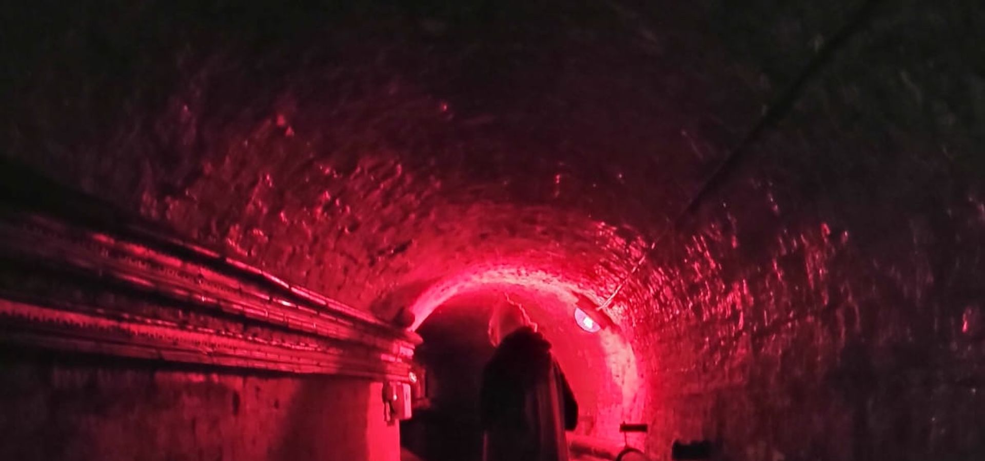 Someone walking through the dark cellars of Temple Newsam