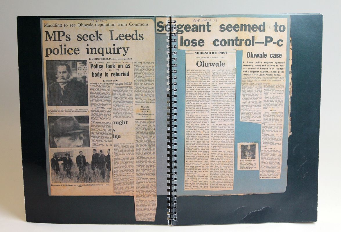 Photograph of newspaper clippings pasted into a book