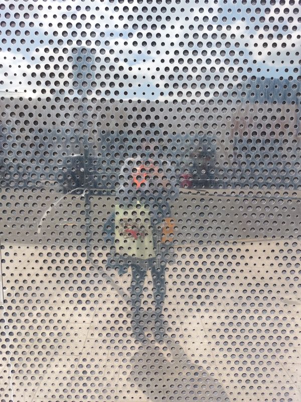The reflection of a person in a steel wall outdoors