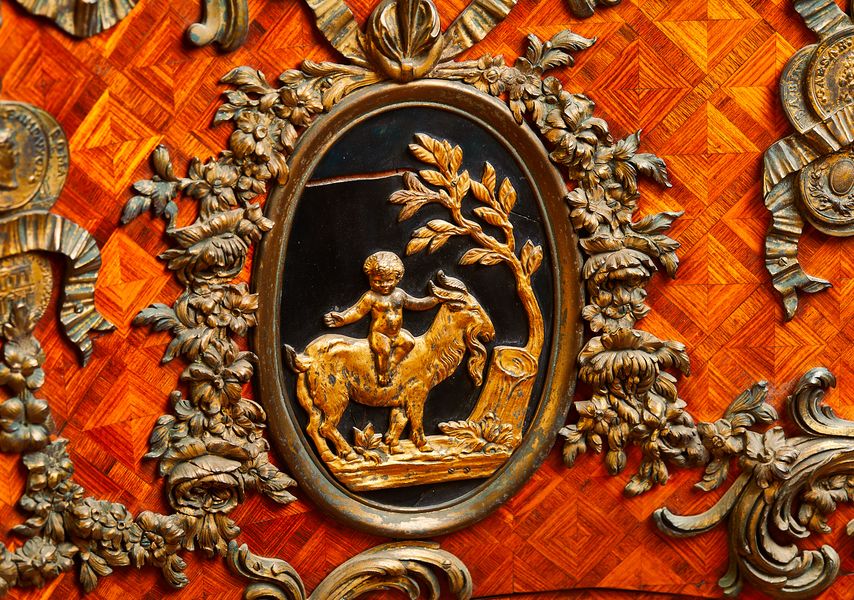 Carved and engraved details on a wooden piece of furniture