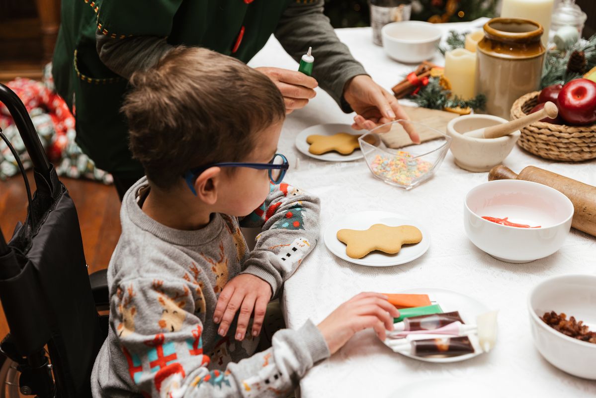 Child icing Christmas biscuits with an Elf at Temple Newsam