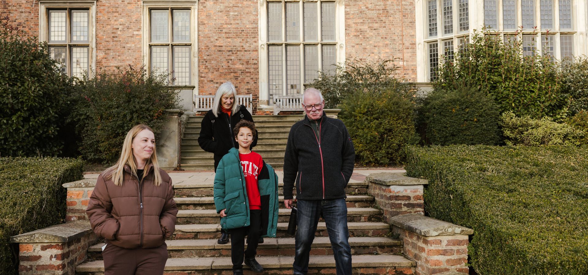 A family walking down steps into a garden at Temple Newsam