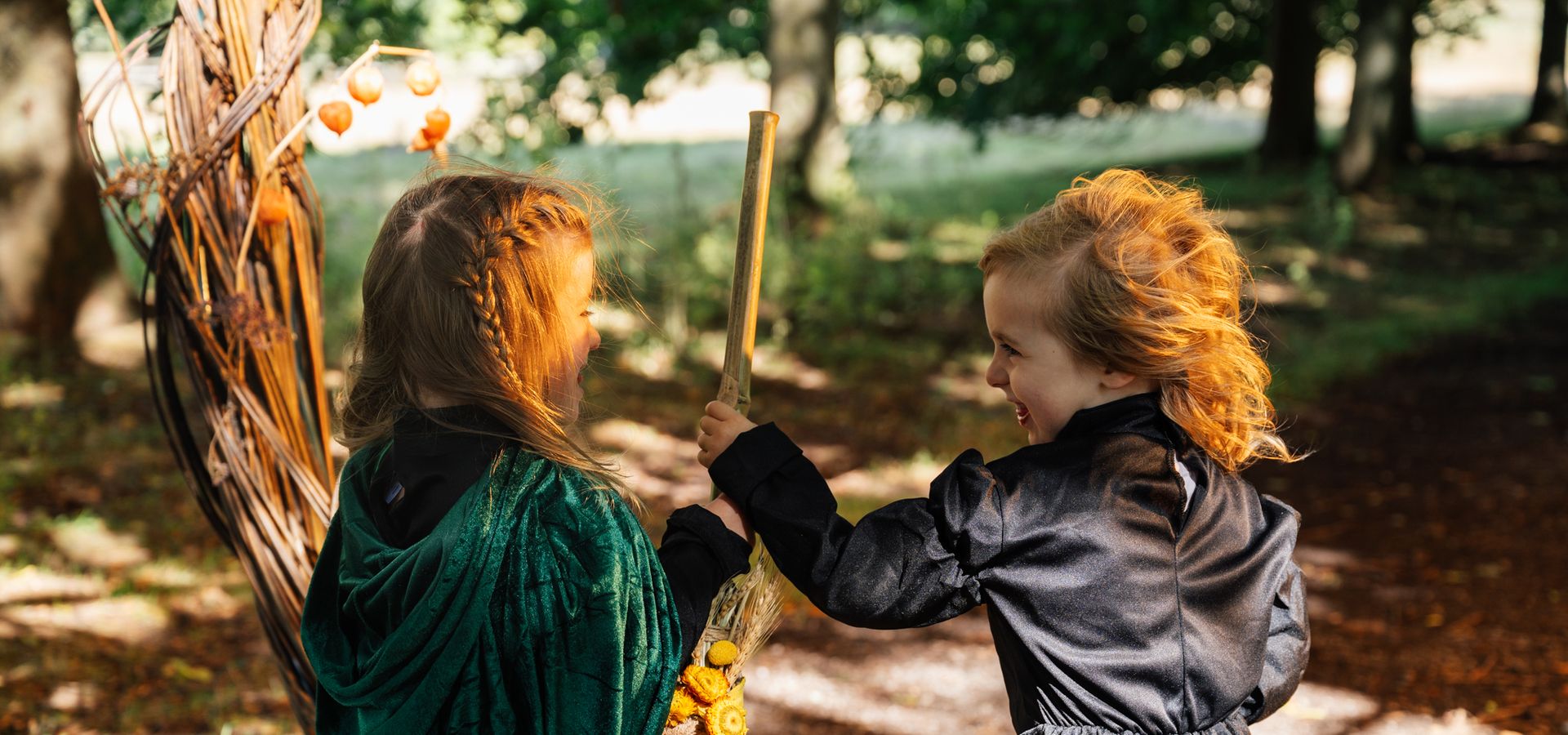 two children in witch costumes holding a broom