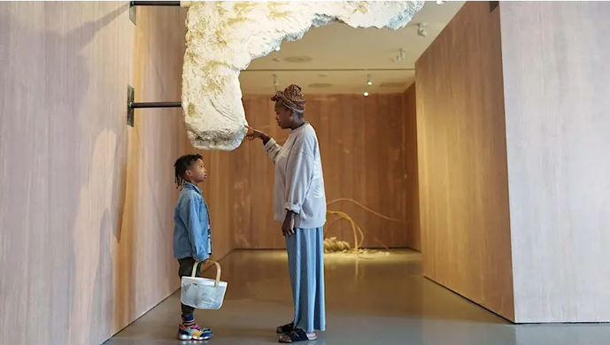 An adult and child looking at sculpture 