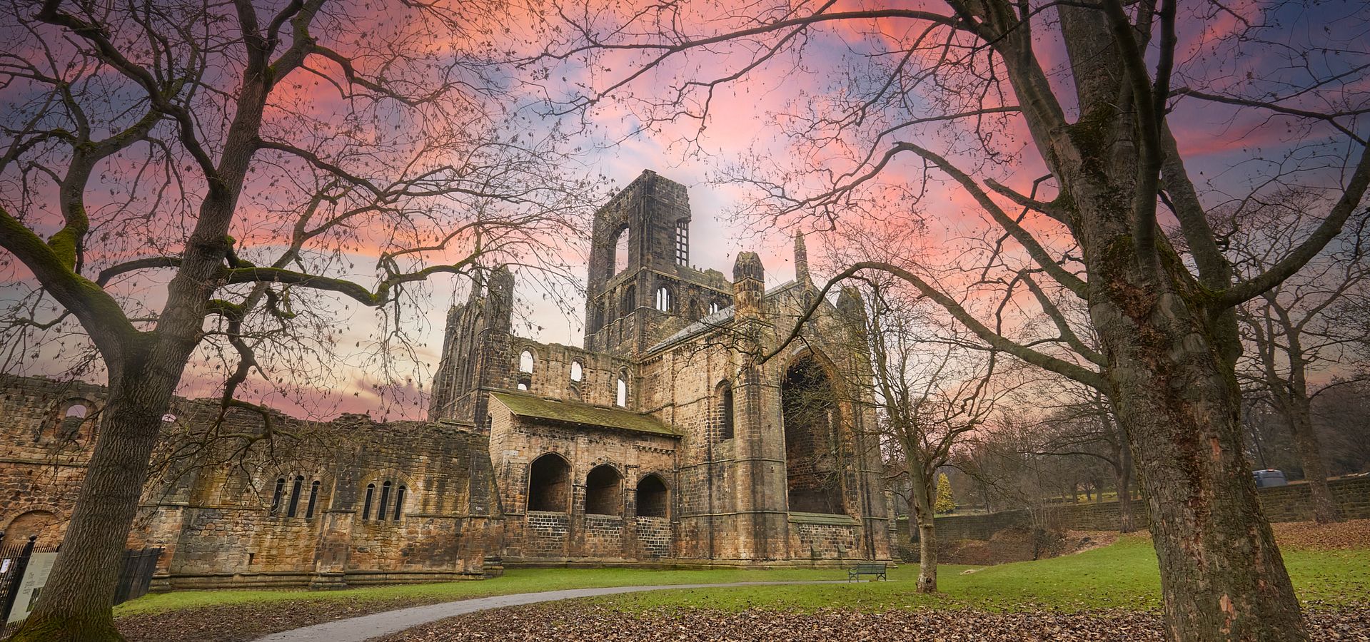 exterior shot of Kirkstall Abbey with red sky in winter