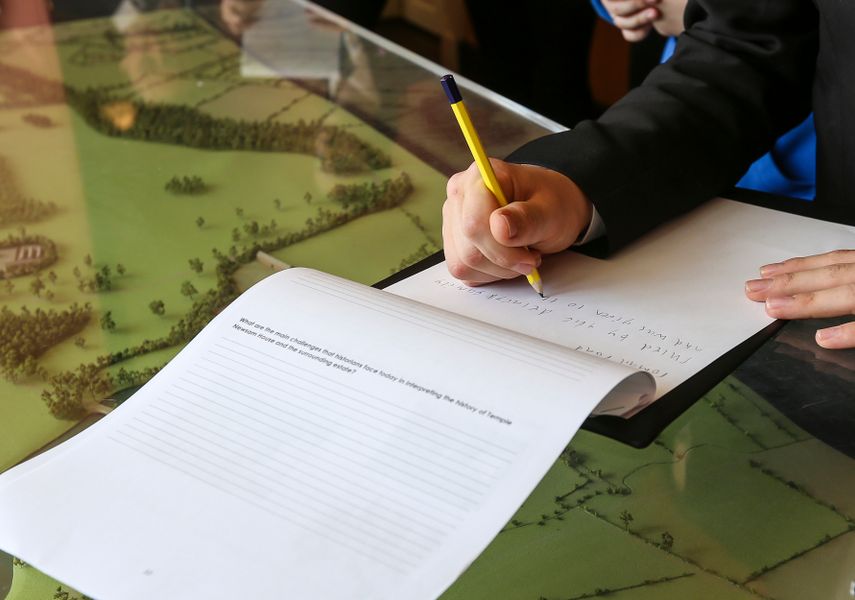 A person holding a clipboard with papers folded over on top of a Temple Newsam 3D map.