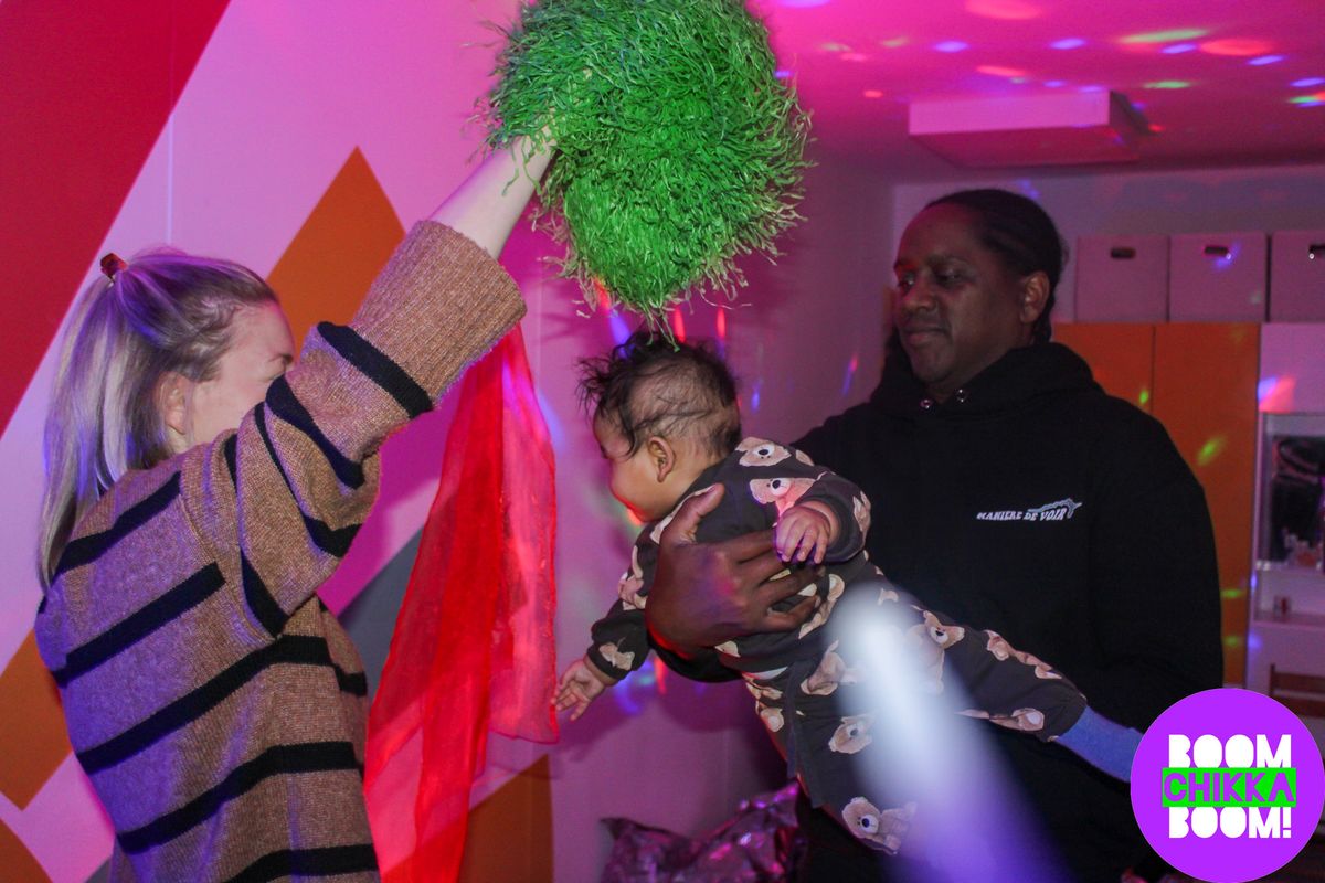 two adults holding a toddler dancing