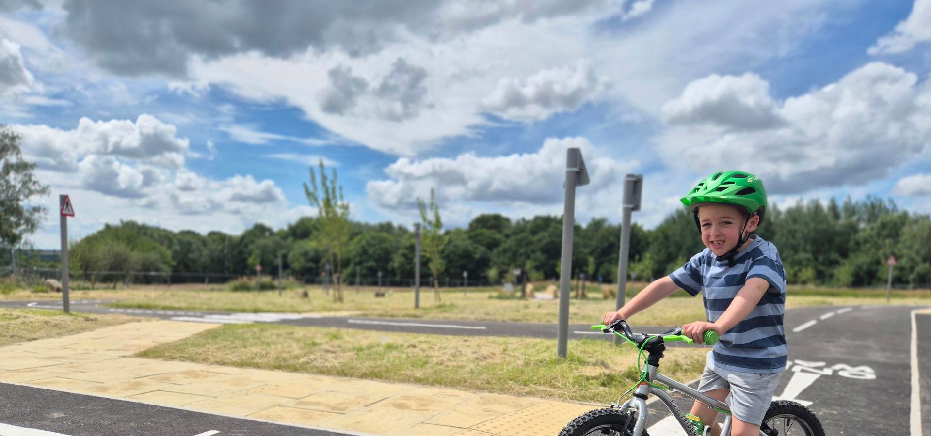 A young boy on a bike with a helmet on at Temple Newsam's new learn to ride park