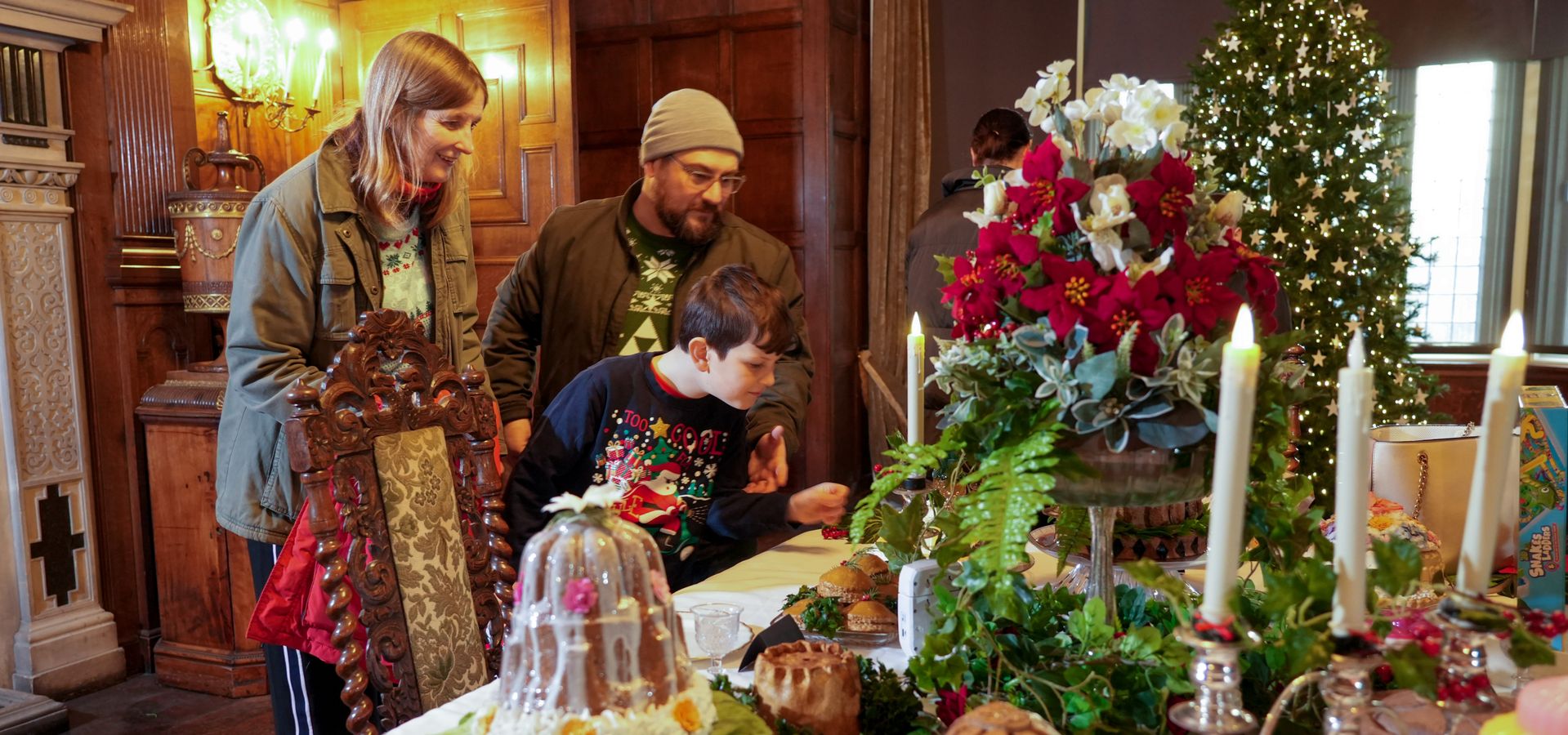 A group of people admiring a festive feast display in the Dining Room of Temple Newsam