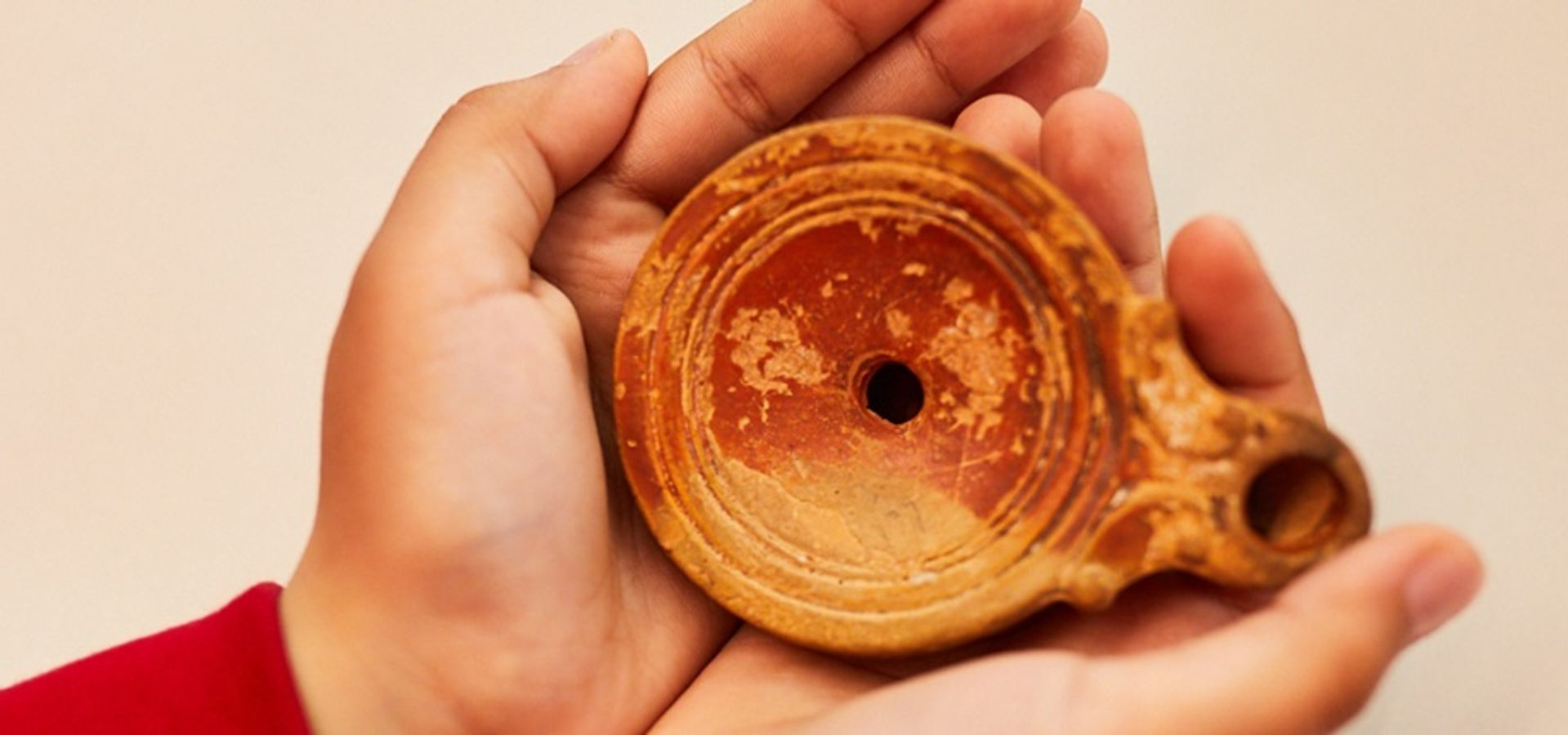 A person holding a piece of ceramic pot