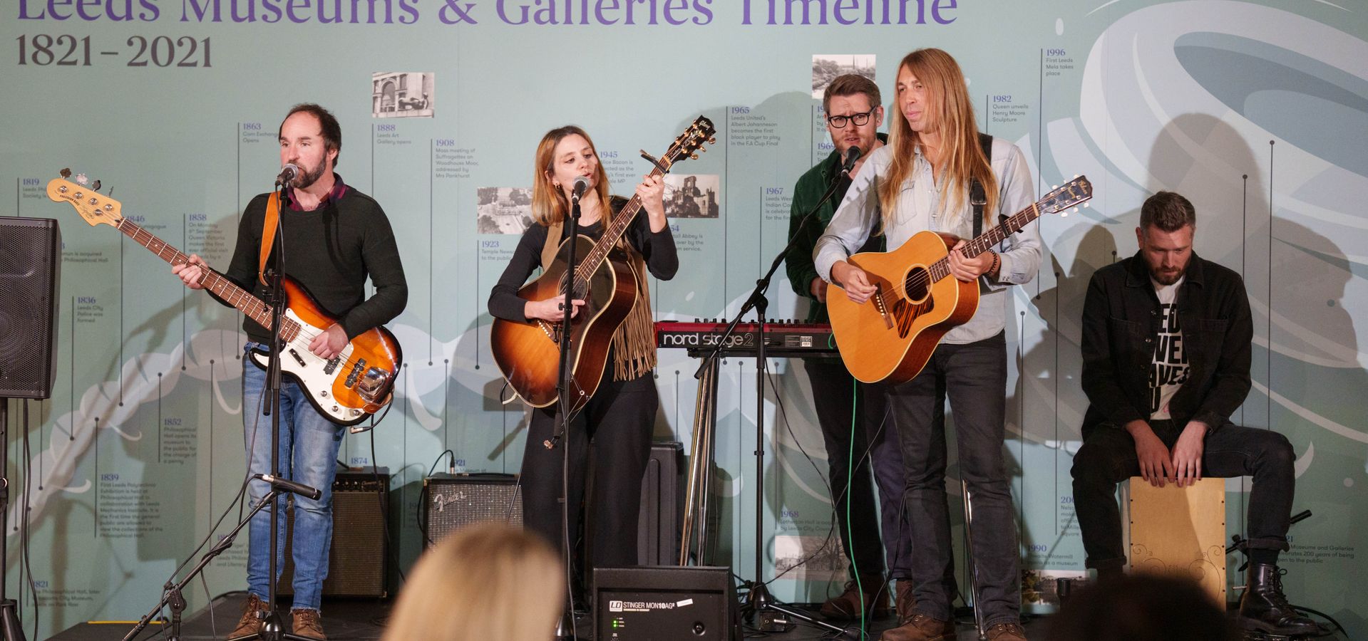 A band of 5 people playing on stage at Leeds City Museum