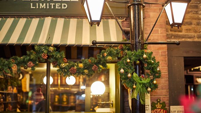 A wreath and christmas garland hanging from a street lamp in Abbey House Museum