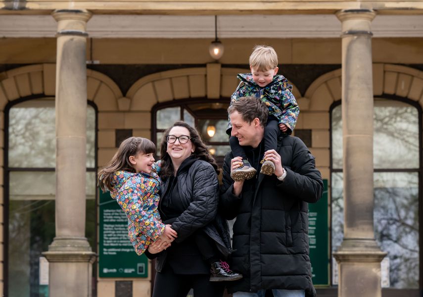 two adults holding children in front of Lotherton Hall