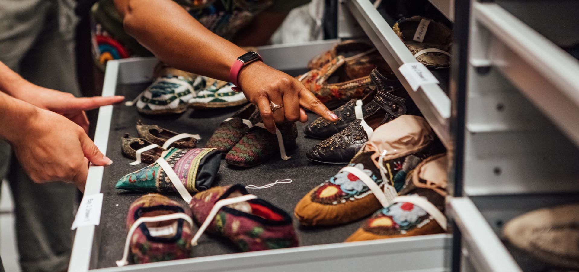 People looking and pointing at shoes in a rack at Leeds Discovery Centre