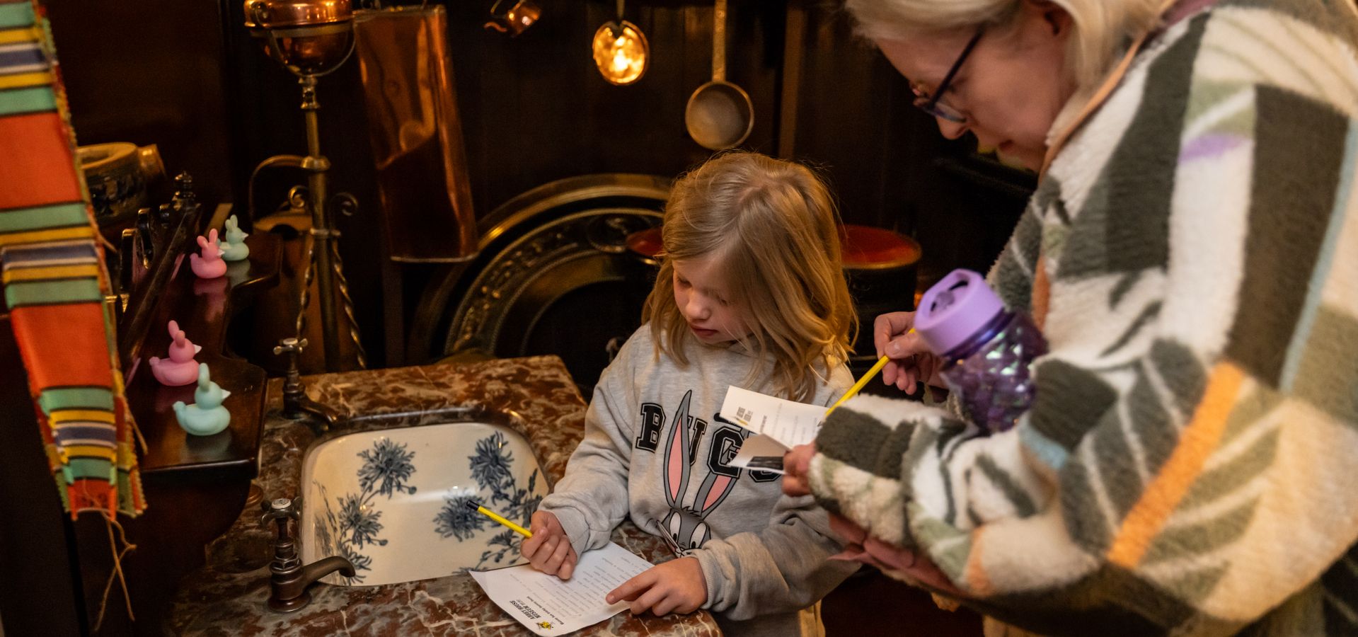 An adult and a child completing a trail sheet at Abbey House Museum