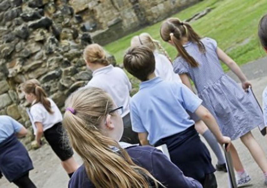 A class of children walk through Kirkstall Abbey