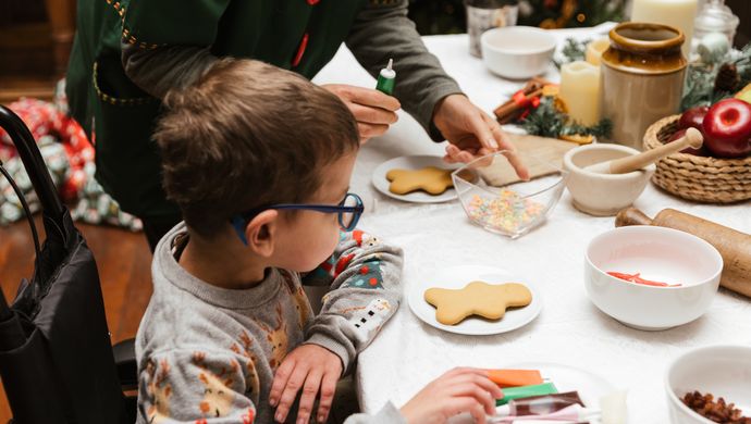 Child icing Christmas biscuits with an Elf at Temple Newsam