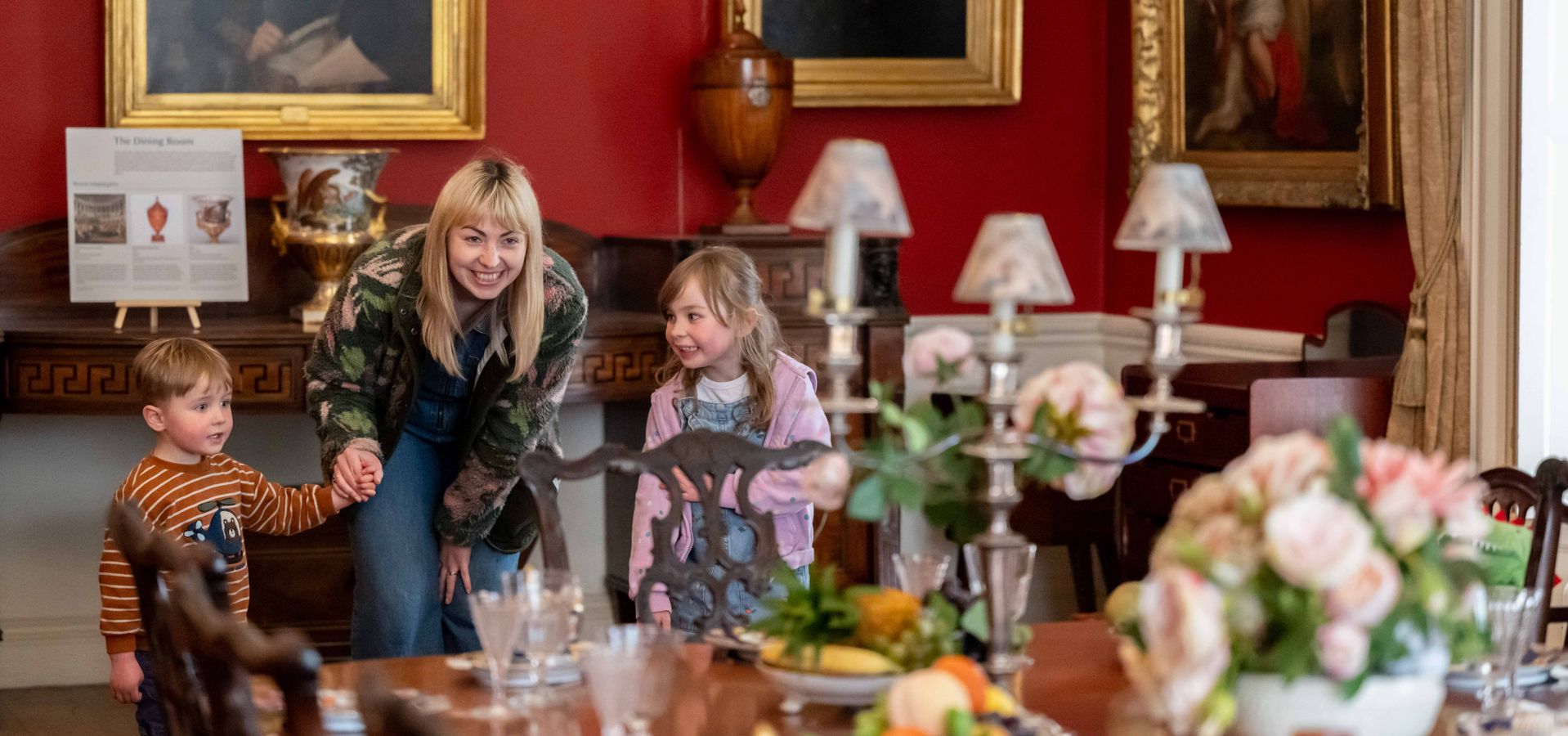 an adult and 2 children looking at a display table in Lotherton house