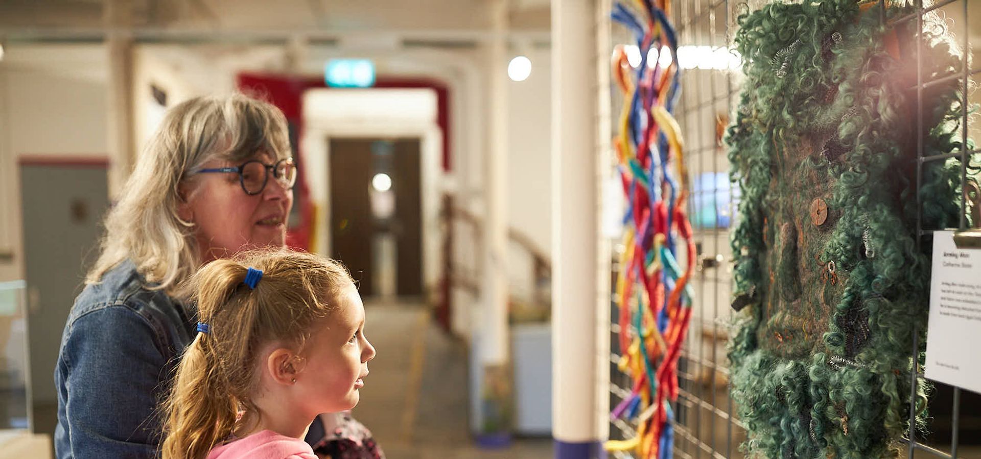 An adult and child looking at a felt exhibition