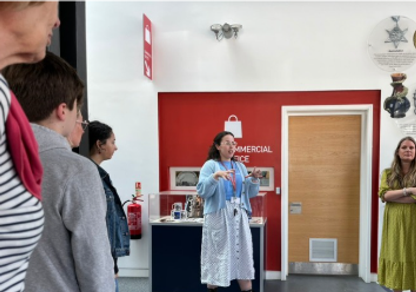 A workshop facilitator in the foyer of Leeds Discovery Centre talking to a group 