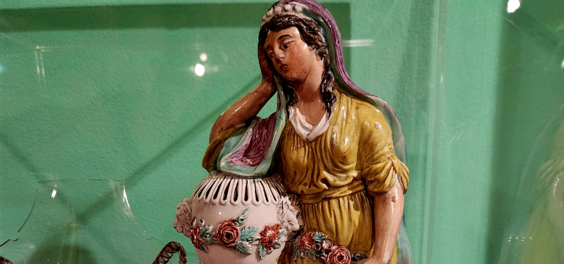 A close up image of a ceramic woman looking mourningful