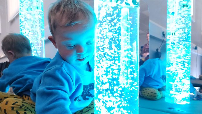 A toddler looking in a sensory toy at Leeds City Museum