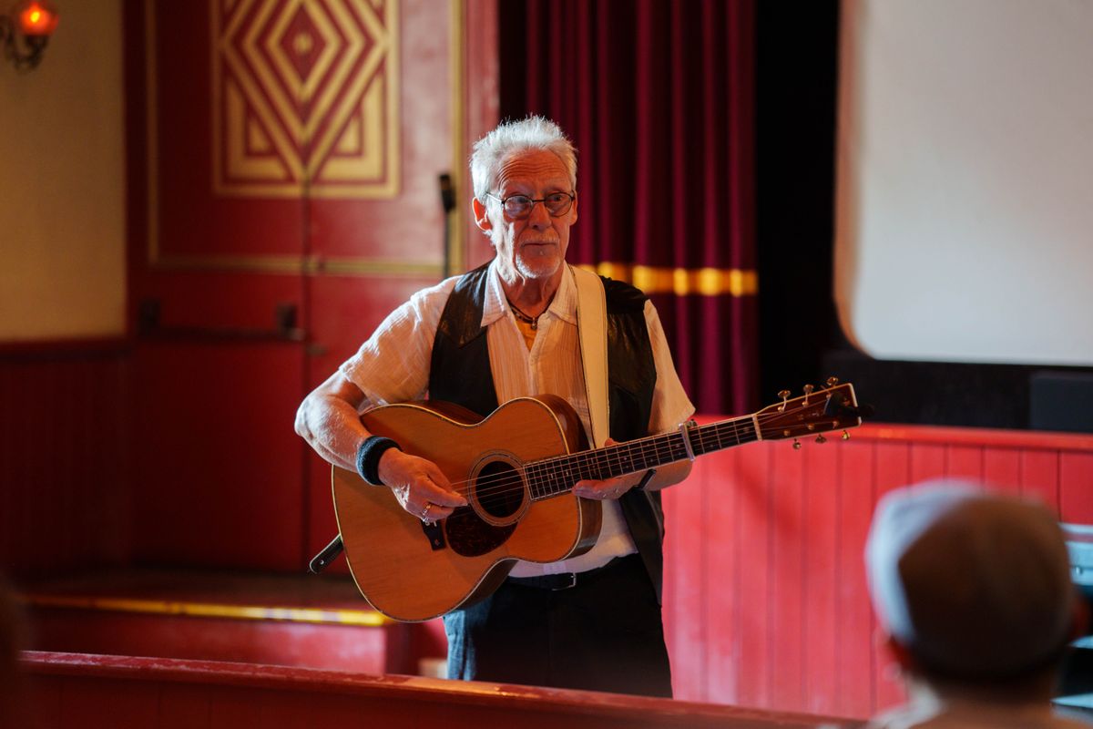 A man playing guitar in Palace Picture House