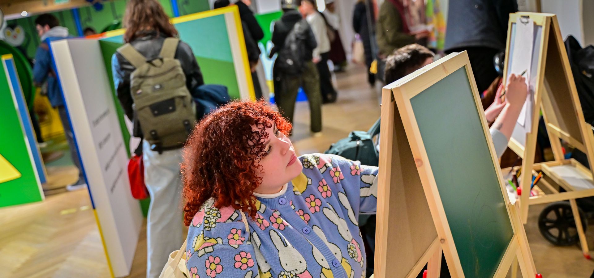 Young person interacting with a chalkboard in the Miffy exhibition