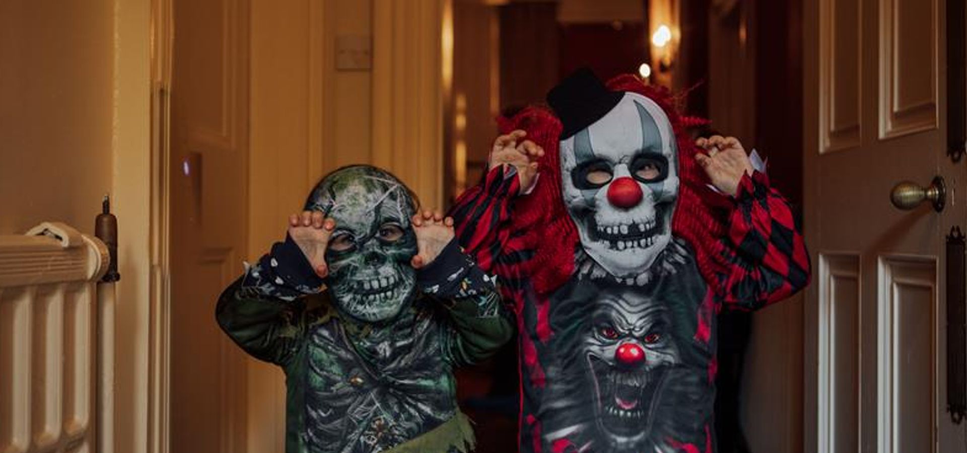 Two children in halloween fancy dress in a corridor