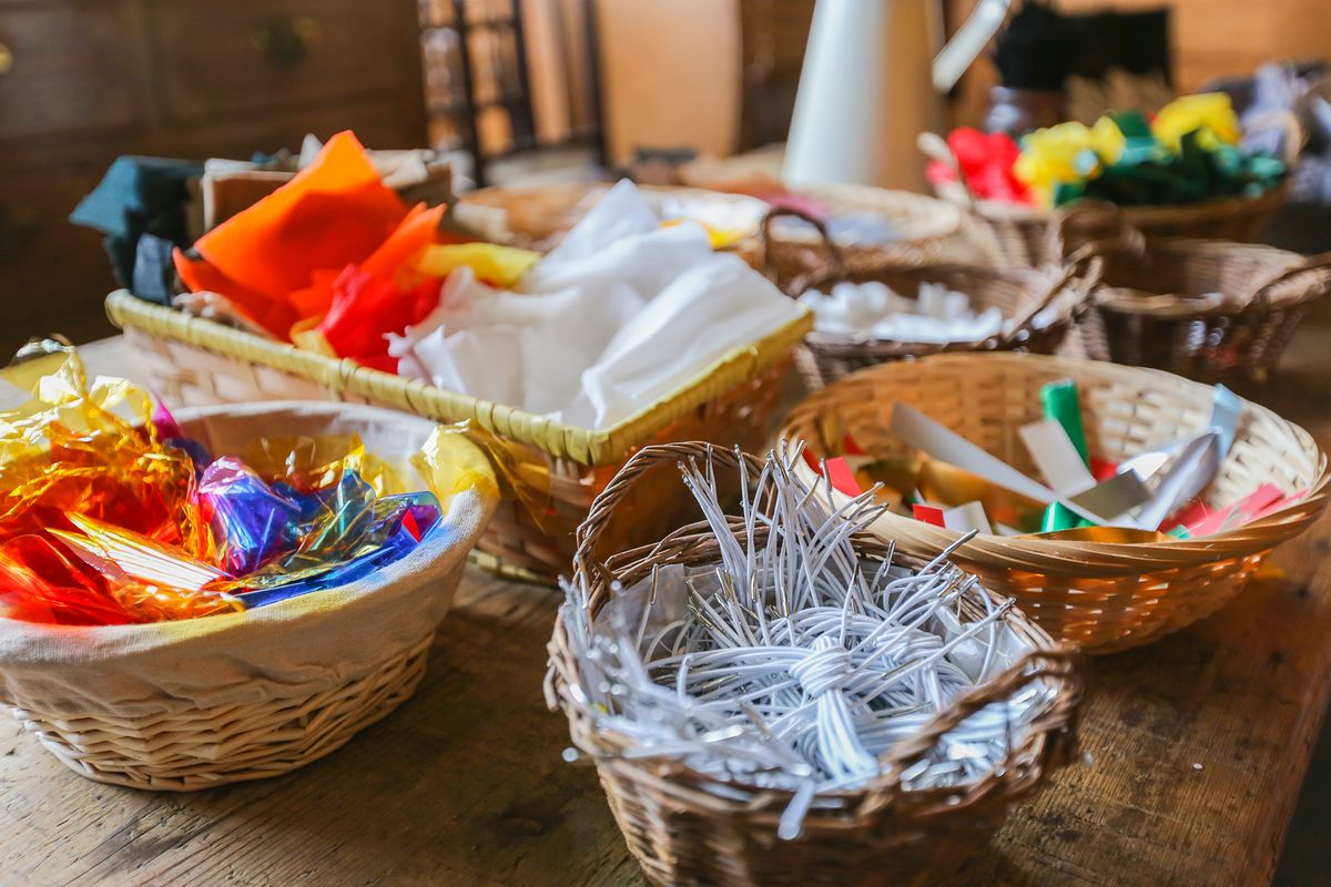 A close up image of baskets of craft materials including strips of coloured paper