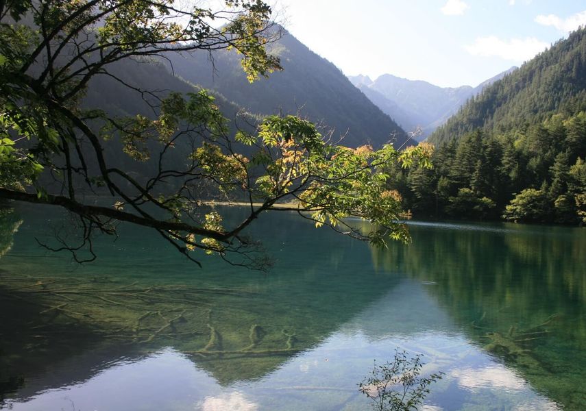 a lake with mountains behind it.