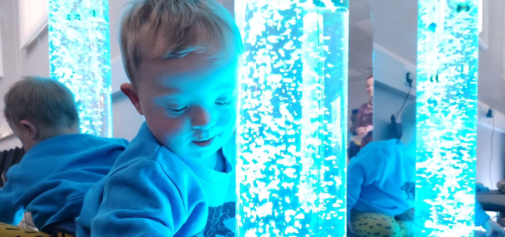 A toddler looking in a sensory toy at Leeds City Museum