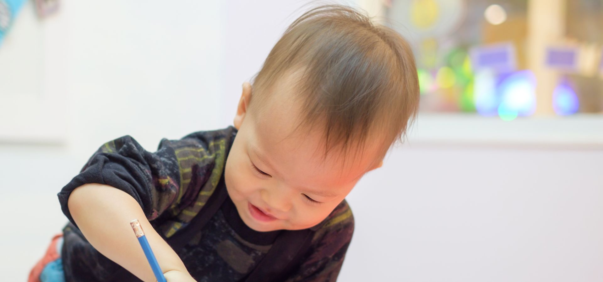 a toddler drawing on a piece of paper
