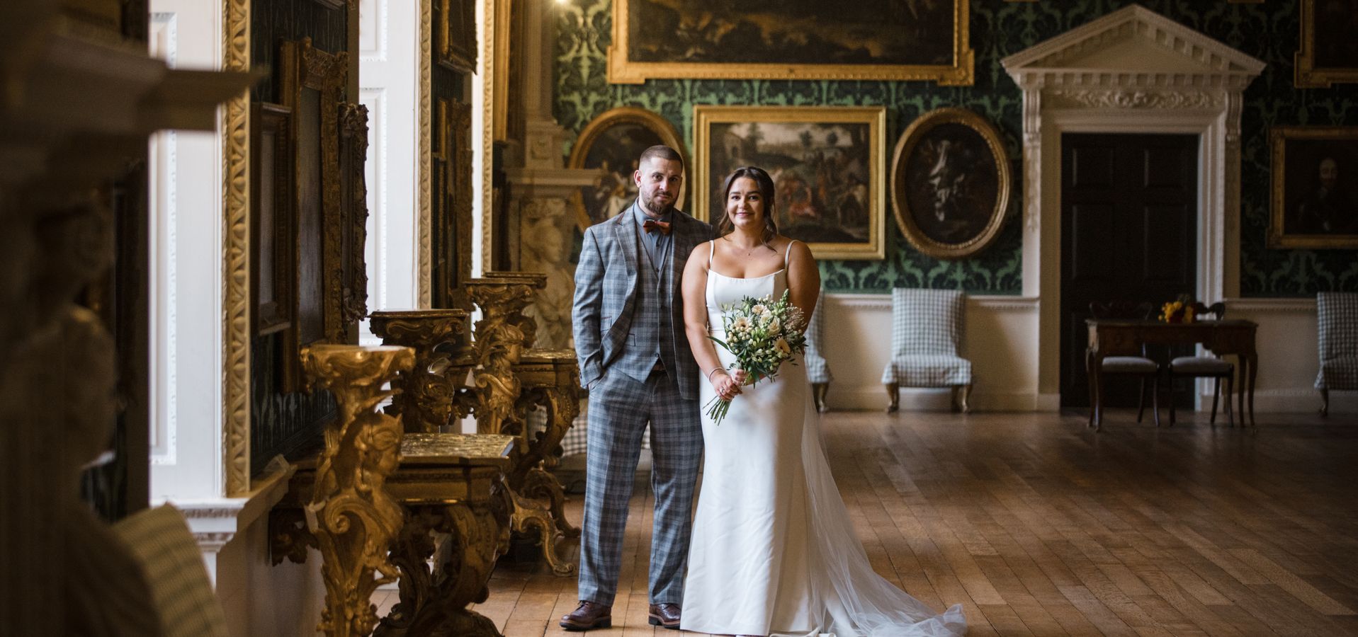 A bride and groom looking at the camera in The Picture Gallery