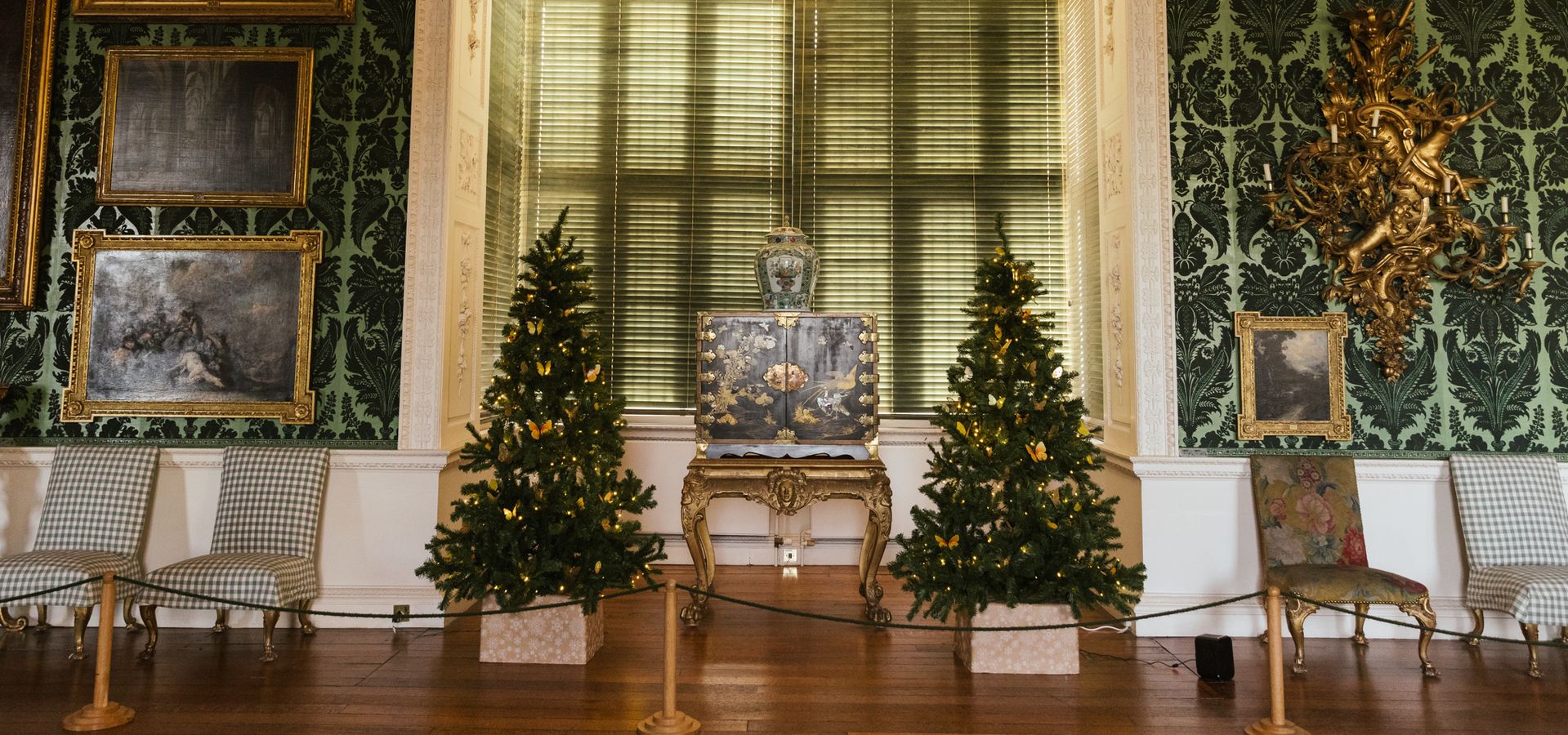 Two Christmas trees in the bay window of The Picture Gallery at Temple Newsam