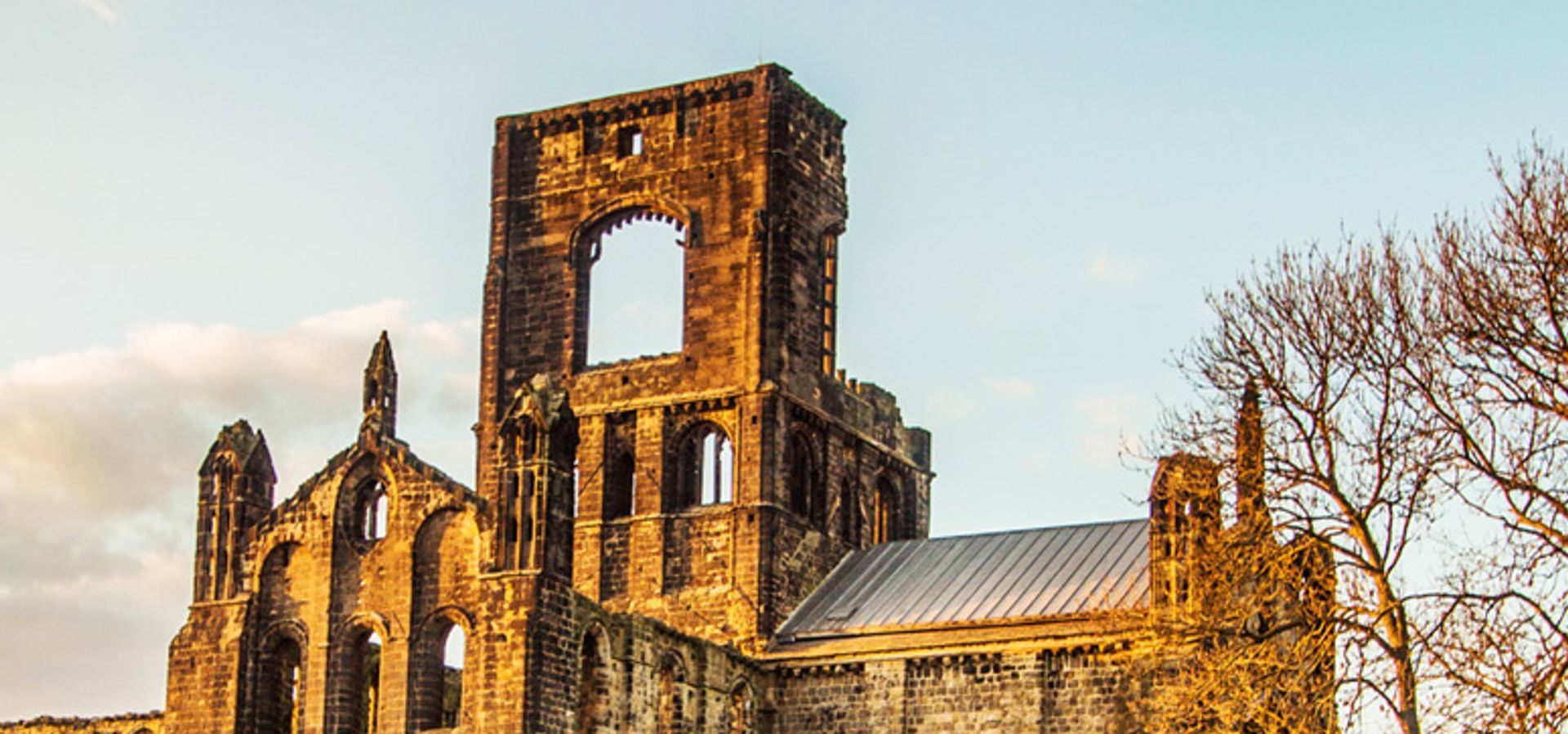 The ruins of Kirkstall Abbey with an evening glow on the stones