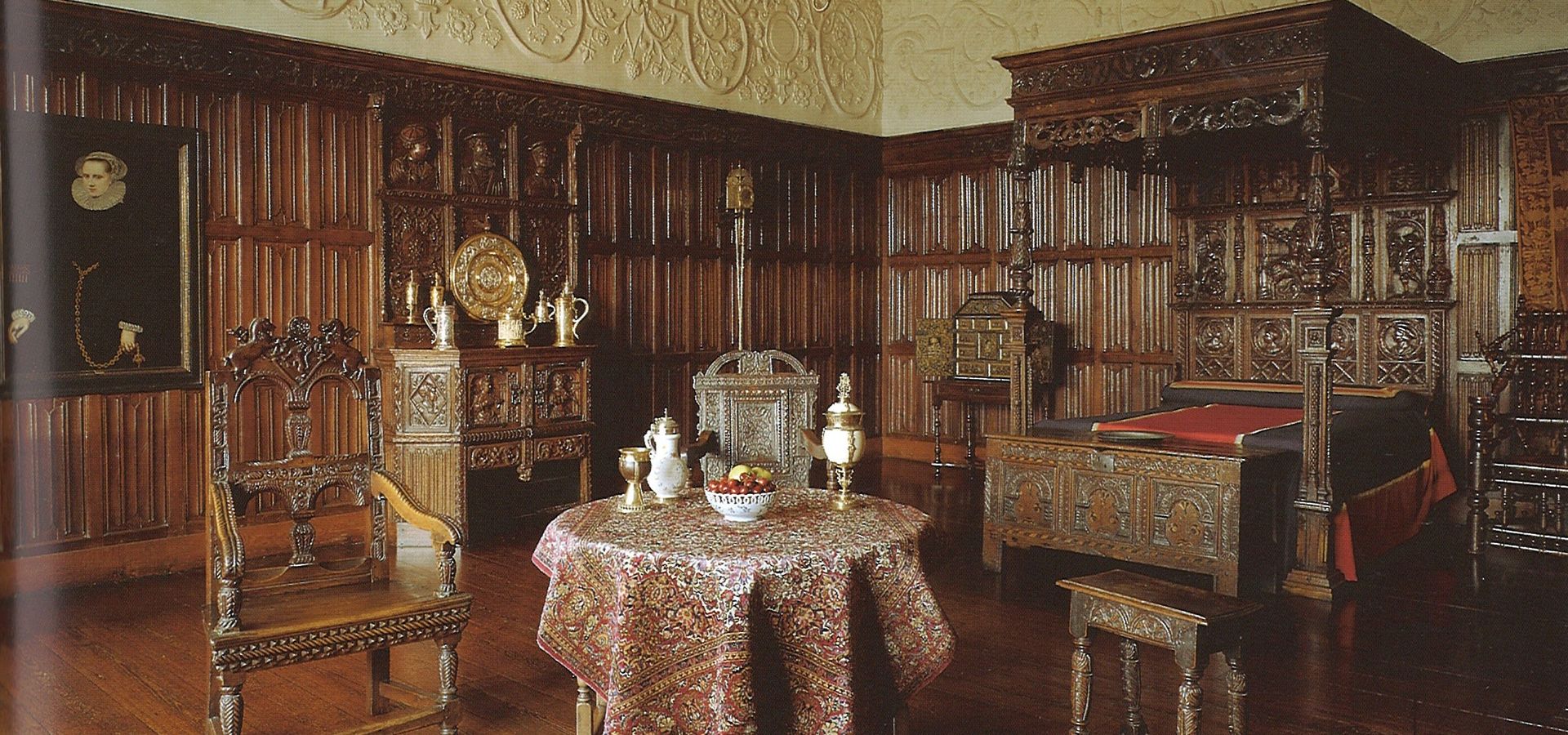 Historic Bretton Room at Temple Newsam featuring dark wood panelled walls, an elaborate carved bed, and antique furnishings