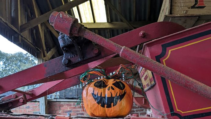 Pumpkin placed on top of red machinery