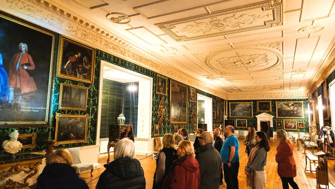 A group of people walking through a large room in Temple Newsam House